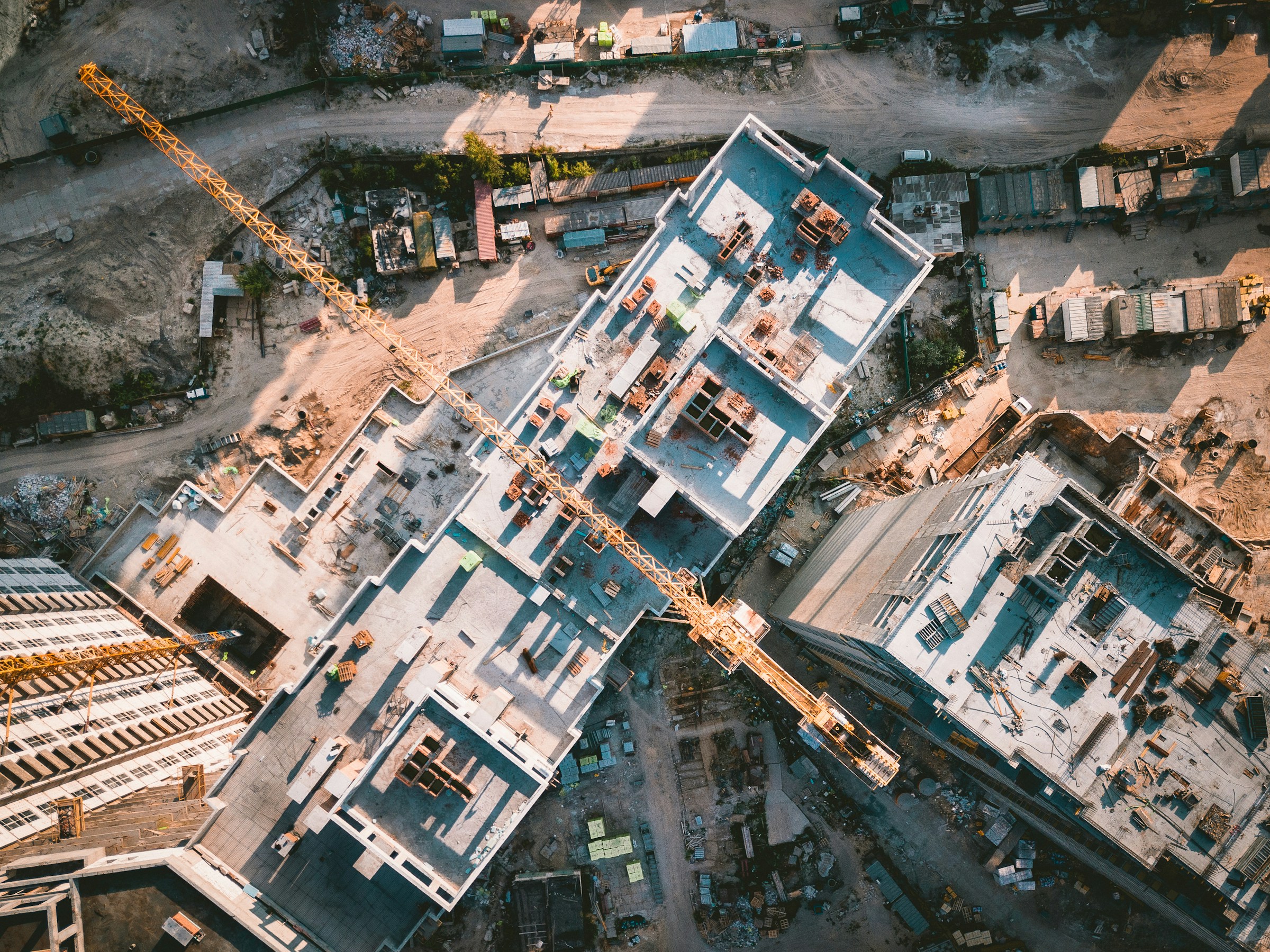 Aerial view of urban buildings under construction with tower cranes